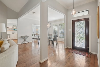 Entryway featuring healthy amount of natural light, wood-type flooring, and crown molding