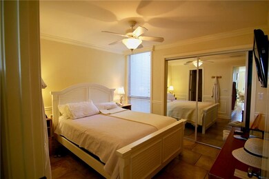 Bedroom with ceiling fan and lspacious closet with