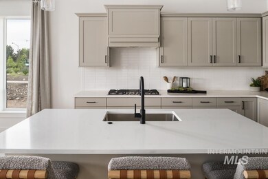 Kitchen featuring gray cabinetry, stainless steel gas stovetop, light countertops, and tasteful backsplash