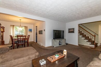 Living room featuring a textured ceiling and carpe