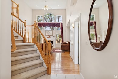 Entrance foyer featuring stairs, a fireplace, plenty of natural light, a ceiling fan, and recessed lighting