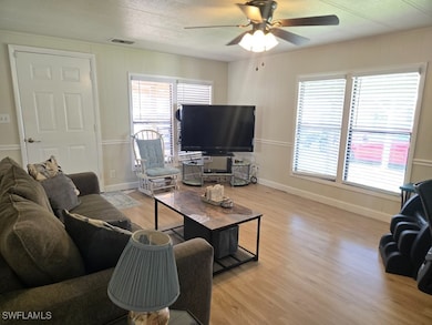 Living room with ceiling fan, a textured ceiling,