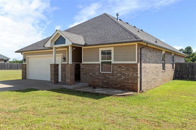 View of front facade featuring a garage, brick siding, a shingled roof, and concrete driveway