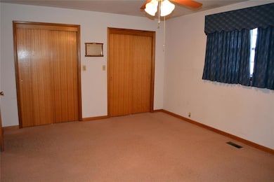 Unfurnished bedroom with ceiling fan, light colored carpet, and a closet