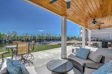 View of patio / terrace featuring a ceiling fan, a water view, and outdoor lounge area