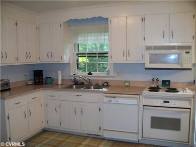 Kitchen - The kitchen has white cabinets, and door