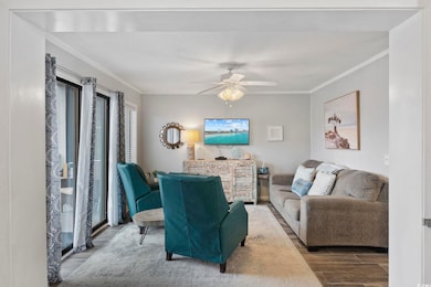 Living room featuring ornamental molding, wood finished floors, and a ceiling fan