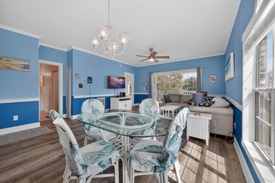 Dining room with ornamental molding, wood finished floors, a chandelier, and ceiling fan
