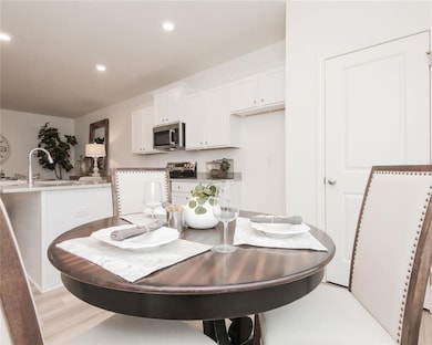 Dining area with recessed lighting and light wood-type flooring