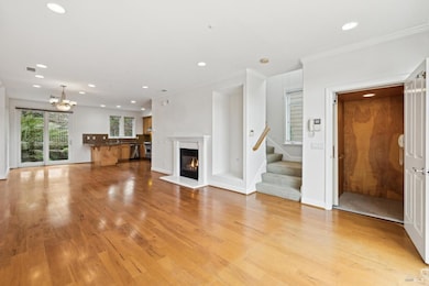 The main floor showing the open floor plan, lush backyard patio, cozy gas fireplace and elevator to the top and bottom floors.