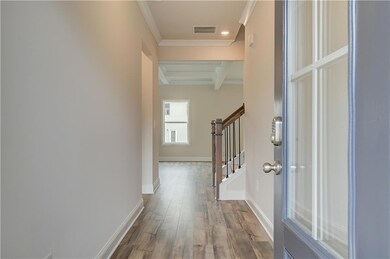 Hall featuring beam ceiling, stairway, wood finished floors, crown molding, and baseboards
