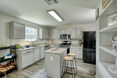 Kitchen with stainless steel appliances, light wo