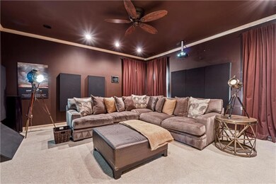 Home theater featuring a ceiling fan, ornamental m
