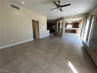 Unfurnished living room featuring ceiling fan, a chandelier, recessed lighting, and light tile patterned floors