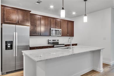 Kitchen featuring light wood-style flooring, dark 