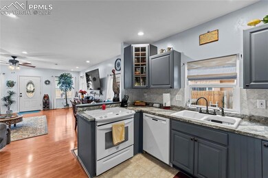Kitchen featuring gray cabinets, glass insert cabinets, backsplash, and recessed lighting