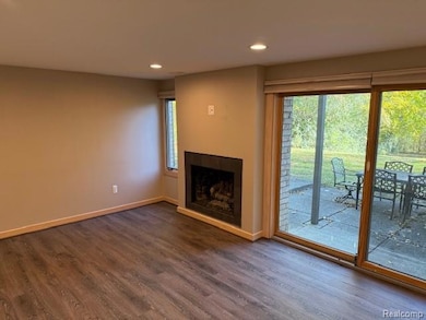 Unfurnished living room with recessed lighting, dark wood-type flooring, and a fireplace