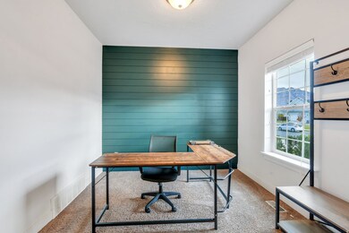 Carpeted home office featuring wooden walls and an accent wall
