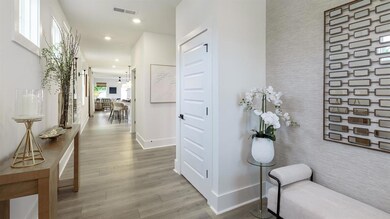 Corridor featuring an accent wall, baseboards, wood finished floors, recessed lighting, and wallpapered walls