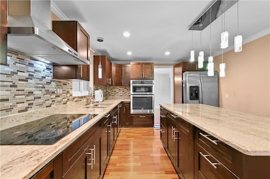 Kitchen featuring crown molding, wall chimney exha