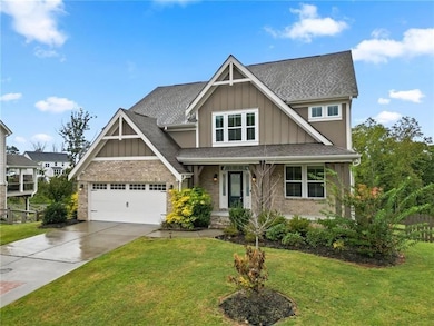 Craftsman inspired home featuring board and batten siding, brick siding, and a front lawn