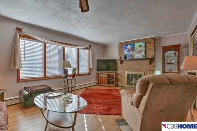 Glowing hardwood floors, woodburning  fireplace, and great set of windows make a wonderful family room.