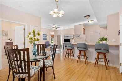 Dining room with wood flooring opens to kitchen & 