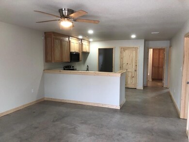 Kitchen featuring concrete flooring, baseboards, a