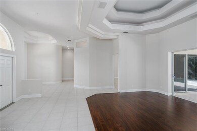 Unfurnished room featuring a raised ceiling and li