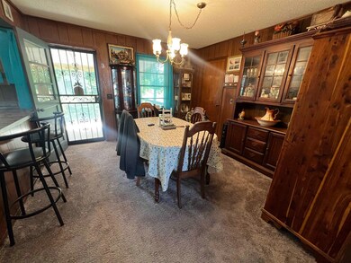 Carpeted dining area with a textured ceiling, wood