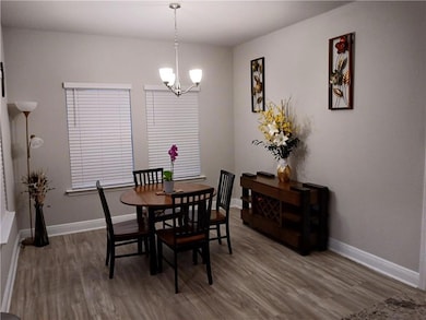 Dining room with wood finished floors and a chandelier