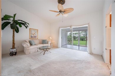 Carpeted living room with ceiling fan and lofted c