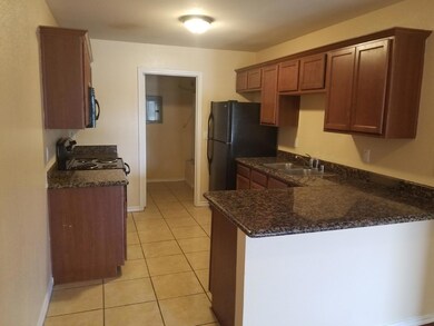 Kitchen with dark stone countertops, sink, kitchen