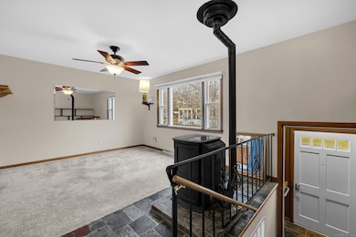 Steps up from the front entrance leads to the living room which features wall-to-wall carpet as well as tile flooring under the pellet stove.