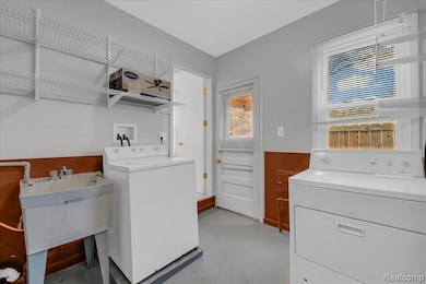 Laundry room with independent washer and dryer and concrete floors