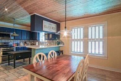 Tiled dining area featuring a wealth of natural light and wood ceiling