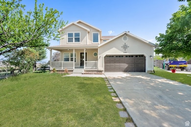 Traditional-style house featuring a porch, a front lawn, driveway, and stucco siding