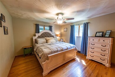 Large master bedroom with hardwood flooring.