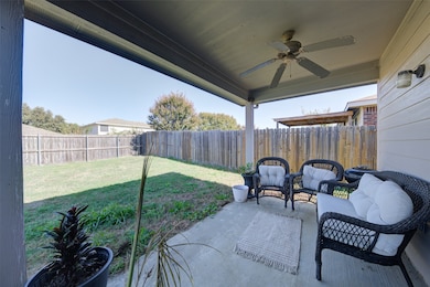 Fenced backyard featuring a ceiling fan, a patio, and an outdoor living space