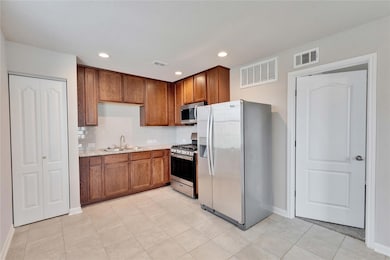 Kitchen with stainless steel appliances, brown ca