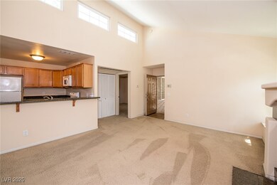 Unfurnished living room featuring light carpet, ba