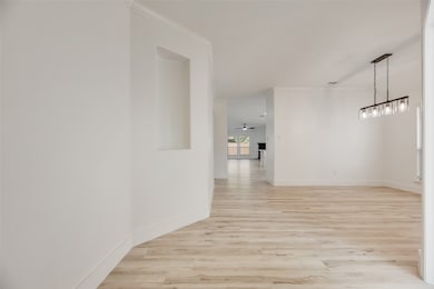 Hall featuring light wood finished floors and ornamental molding