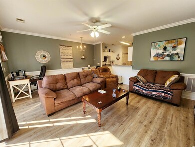Living room featuring ceiling fan with notable cha