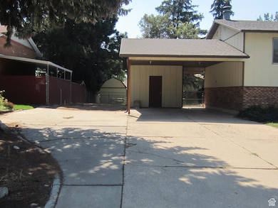 Garage featuring concrete driveway and a carport