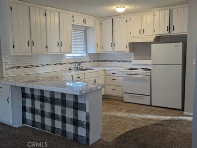Kitchen with lovely tile treatment and newer stove and fridge.