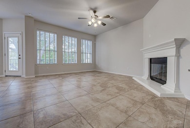 Unfurnished living room with a fireplace, ceiling fan, and light tile patterned flooring