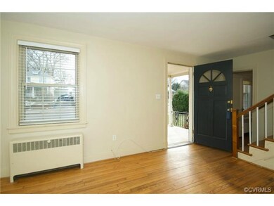 The living room has hardwood floors, two windows w