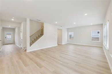 Unfurnished living room featuring plenty of natural light, stairway, recessed lighting, and light wood finished floors