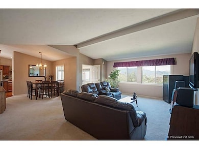 The open floor plan of the main home includes the Living Room which has vaulted ceiling, custom paint & large picture windows to admire the extensive views.