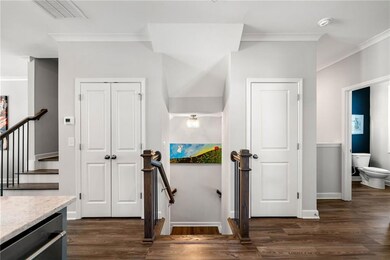 Stairs with wood finished floors, crown molding, baseboards, and visible vents